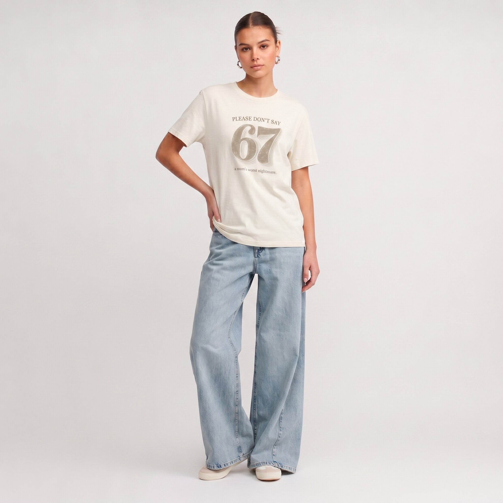 Kiksy cream funny mum t-shirt featuring the slogan Please don't say 67 a mum's worst nightmare, modelled by a woman.