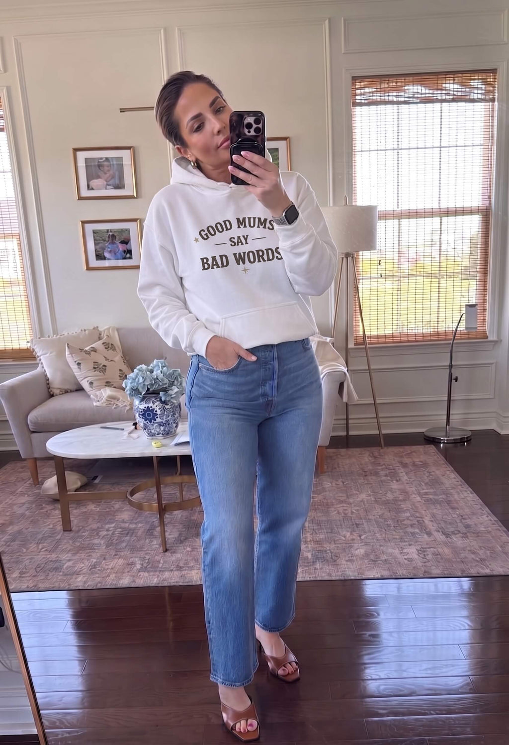 Kiksy white hoodie with Good Mums Say Bad Words printed on the front worn by a smiling woman