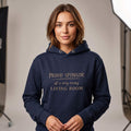 Woman wearing Kiksy dark blue hoodie featuring the text Proud Sponsor of a very messy LIVING ROOM
