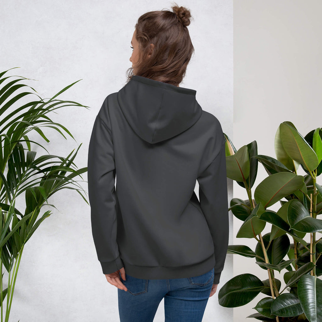 Woman smiling in a Kiksy charcoal grey hoodie featuring a cream square MAMA chest logo.