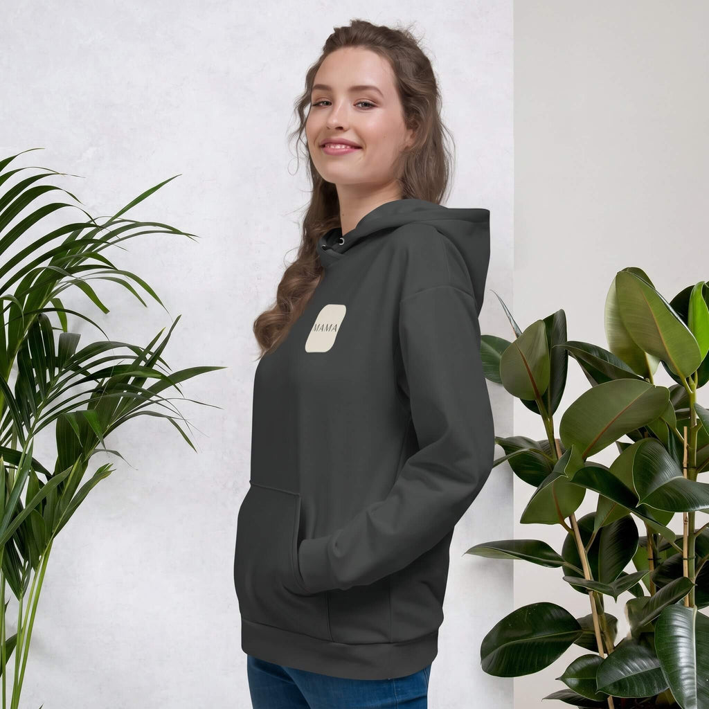 Woman smiling in a Kiksy charcoal grey hoodie featuring a cream square MAMA chest logo.
