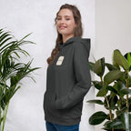 Woman smiling in a Kiksy charcoal grey hoodie featuring a cream square MAMA chest logo.