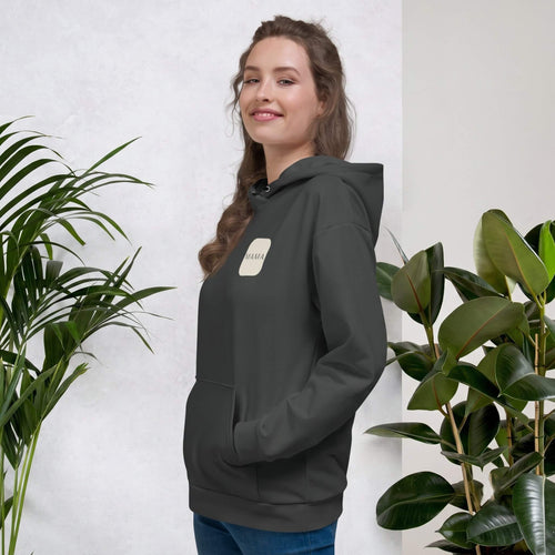Woman smiling in a Kiksy charcoal grey hoodie featuring a cream square MAMA chest logo.